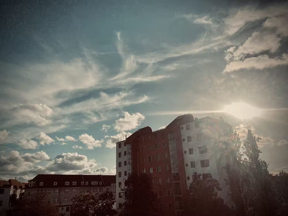 Sun behind an apartment block