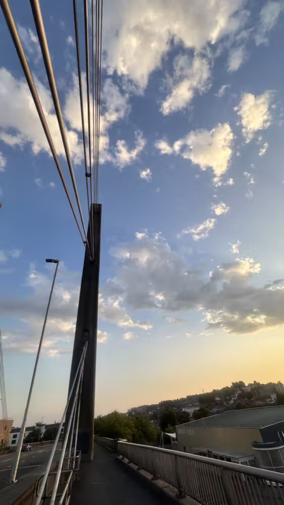 Bridge cables against a cloudy sky