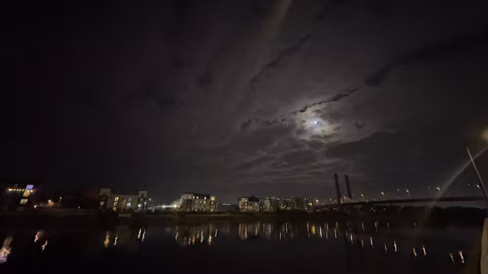 Moon over the city lights across the river