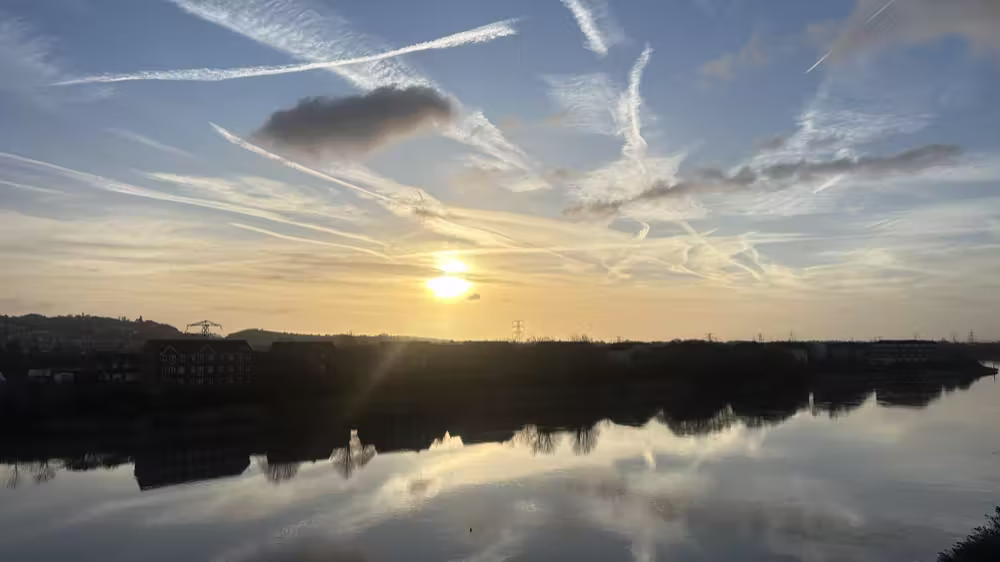 Sunset and contrails over the river