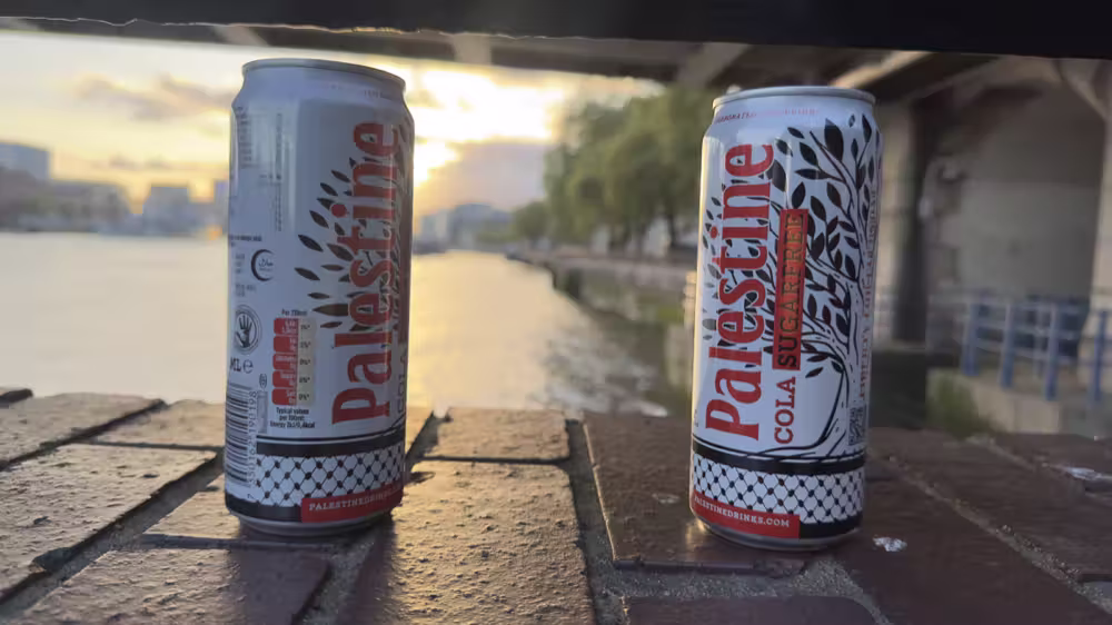 Two cans of Palestine Cola by the river