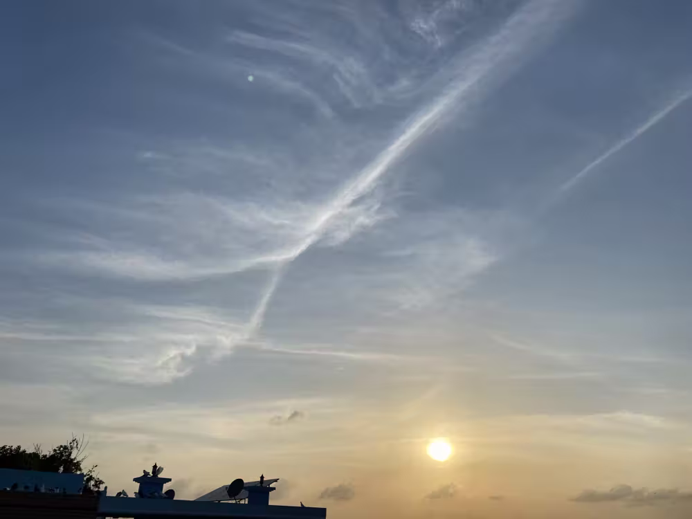 Wispy clouds over the rooftops at sunset