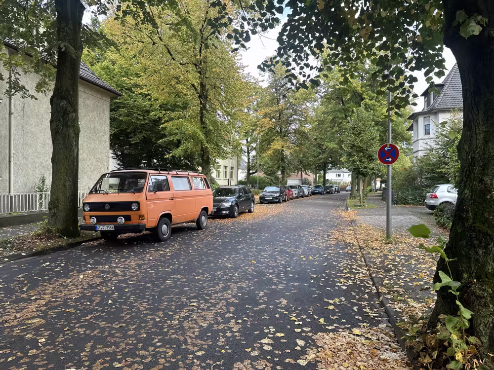 Orange camper van on an autumn street