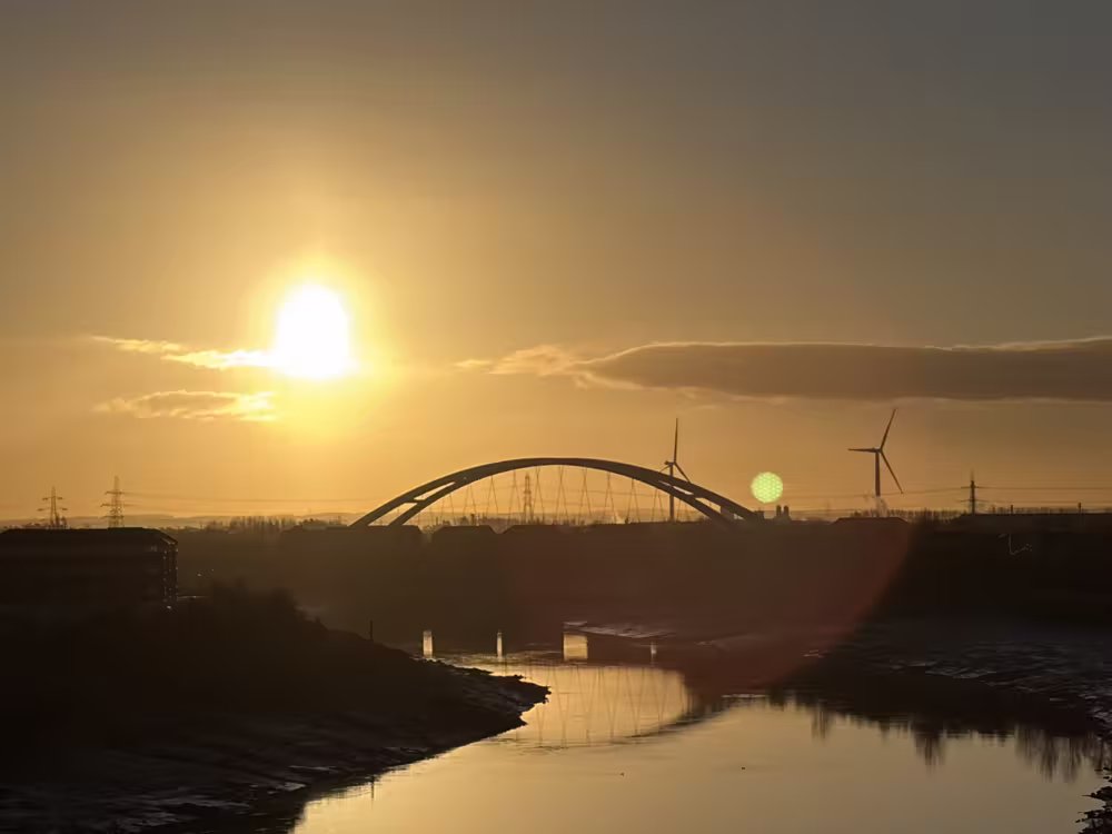 Sunset over the river and the arch bridge